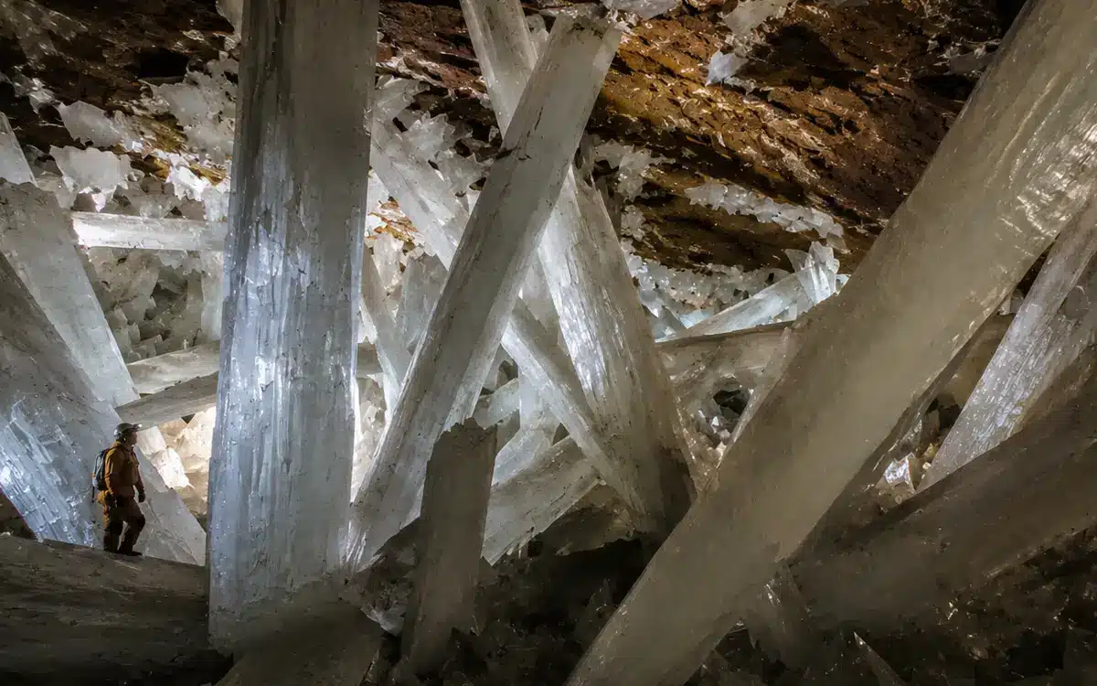 Dentro de la Cueva de los Cristales se aprecia una persona con equipo de exploración, lo que ayuda a mostrar la enorme escala de los cristales.