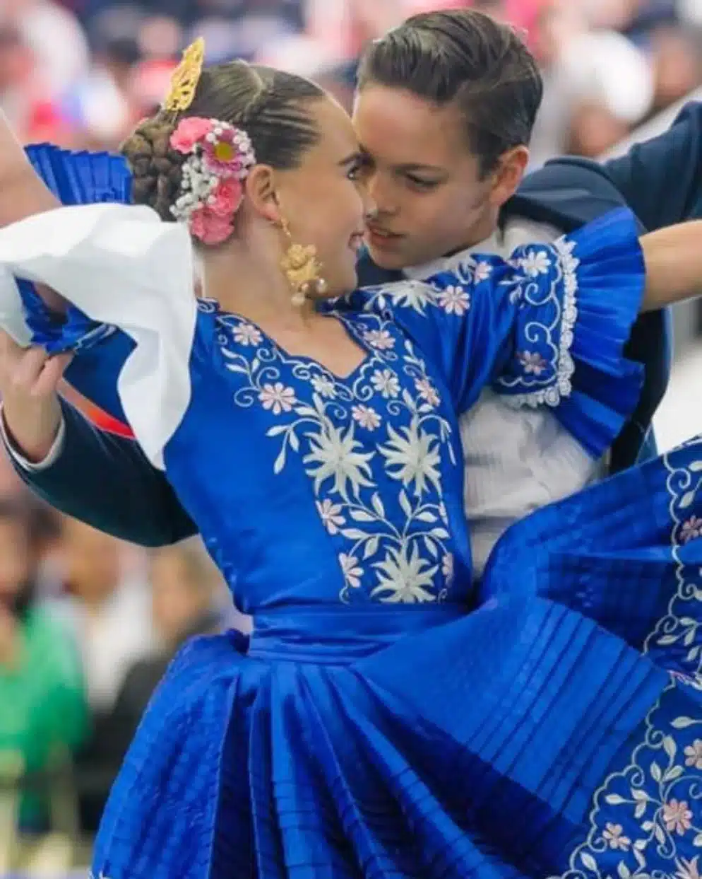 Pareja de marinera norteña con trajes azules tradicionales durante una presentación cultural peruana
