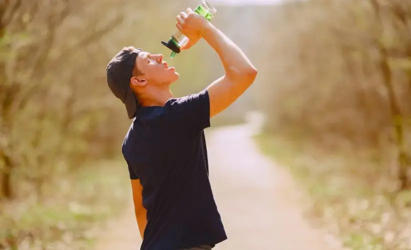 Explorer drinks water to stay hydrated and reduce altitude sickness symptoms.
