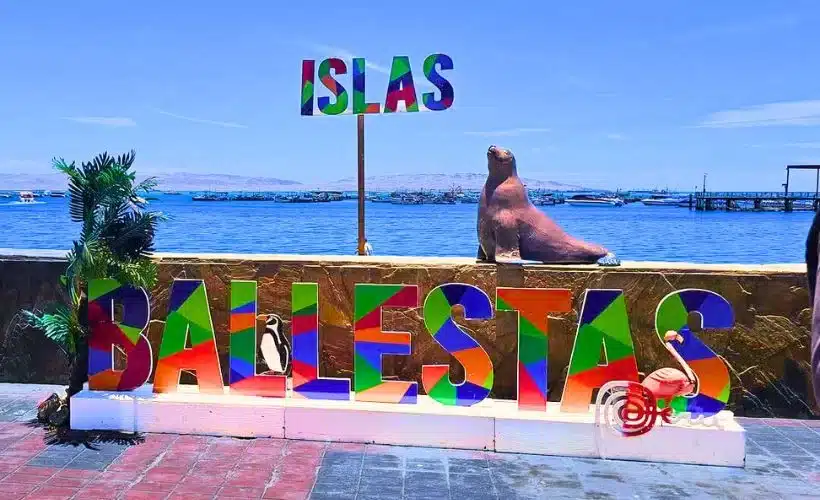 Tour boat near the Ballestas Islands in Paracas, Peru, surrounded by rocky cliffs, seabirds, and calm blue waters, highlighting the area’s rich marine biodiversity and natural beauty.