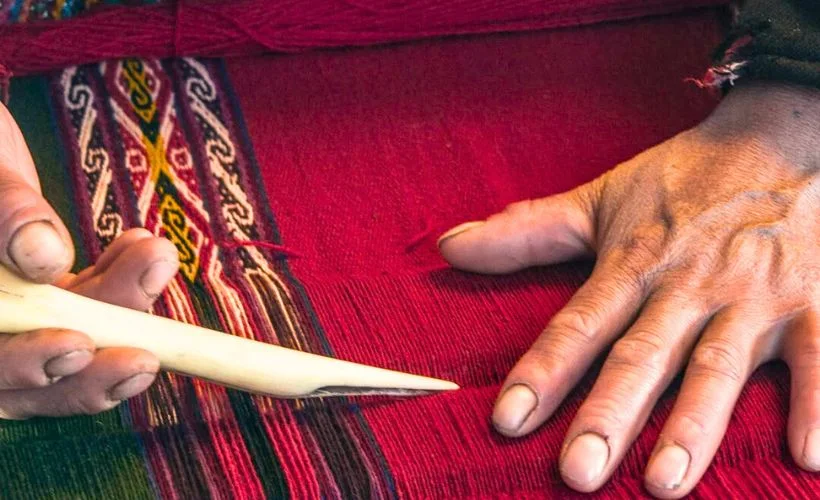 A young artisan learns to weave alongside her mother in Chinchero, Sacred Valley. Their colorful garments and traditional looms reflect Andean heritage and craftsmanship.