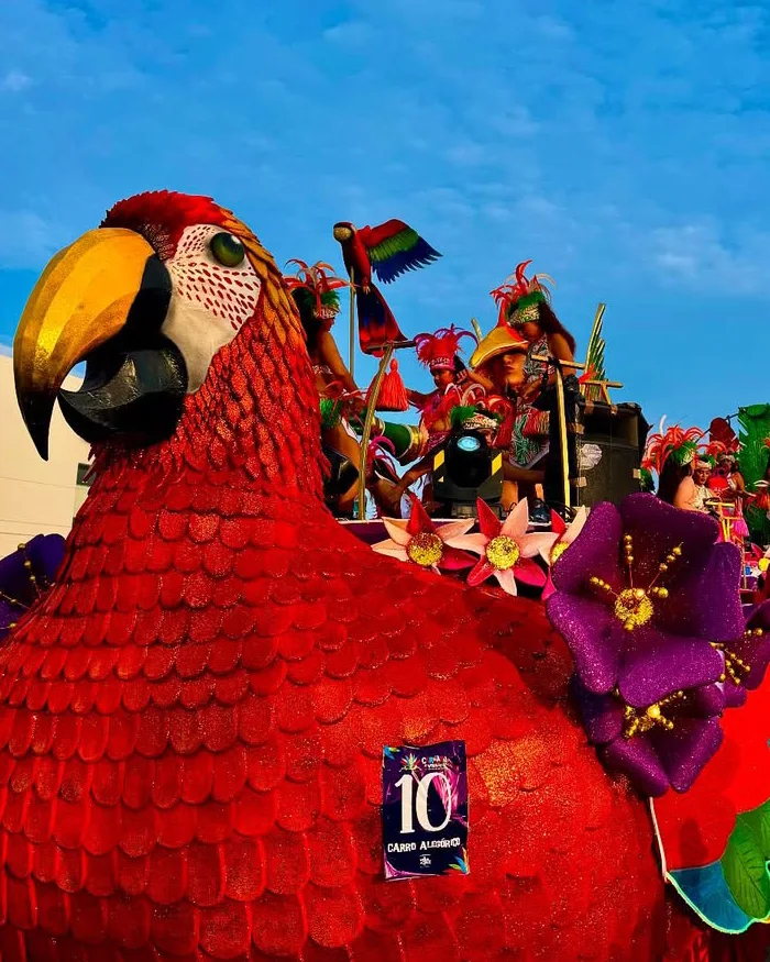Dancers in colorful costumes perform along a crowded city street during a festival parade, with spectators watching vibrant choreographies inspired by salsa, cumbia, and traditional rhythms.