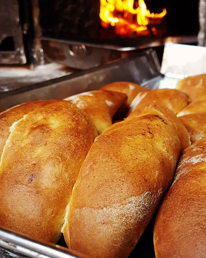 Unas empanadas doradas de Pisac recién salidas del horno de leña muestran su corteza crujiente y aroma artesanal.