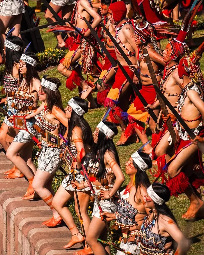 Performers from the jungle region participate in Inti Raymi wearing vibrant costumes and feathered accessories, showcasing Amazonian traditions while dancing during the Cusco winter solstice festival.