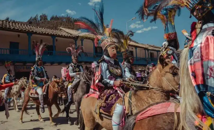 Dancers in feather headdresses and vibrant Amazonian costumes perform the Dancers in feather headdresses and vibrant Amazonian costumes perform the qapac Chunchos dance during the Virgen del Carmen festival in Paucartambo, Cusco, surrounded by music and spectators. Ch’unchos dance during the Virgen del Carmen festival in Paucartambo, Cusco, surrounded by music and spectators.