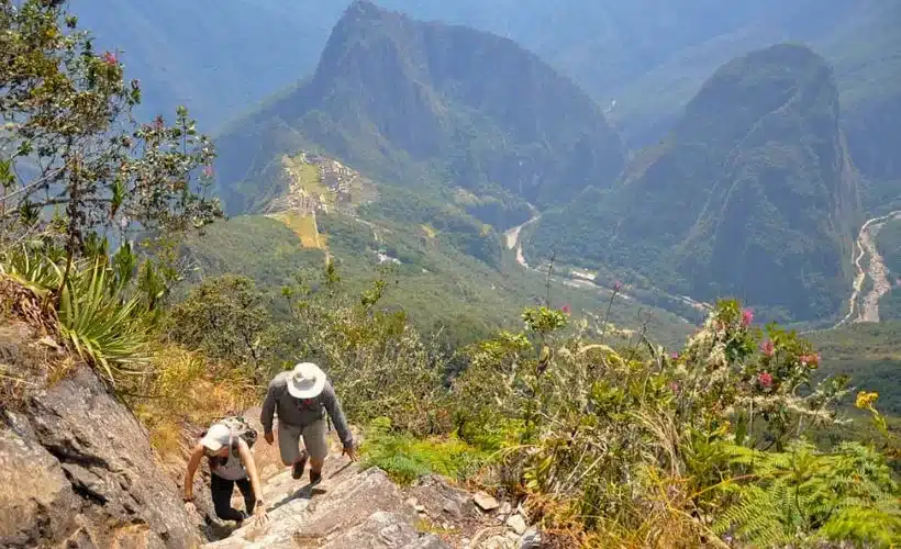 Los turistas realizan una caminata de subida a la montaña Machu Picchu.