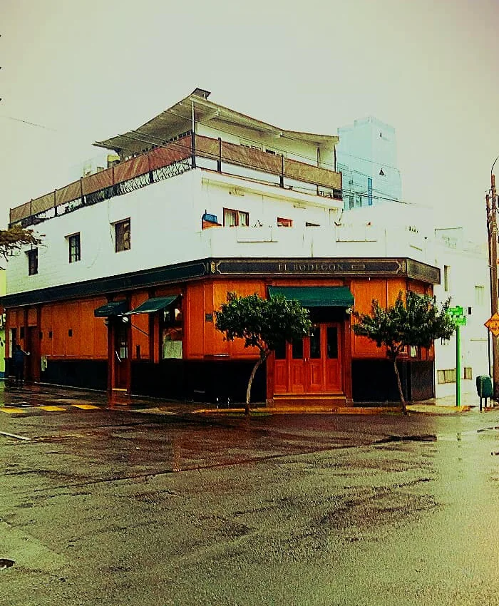 Se observa una esquina urbana con un edificio clásico de dos pisos que alberga el restaurante El Bodegón.