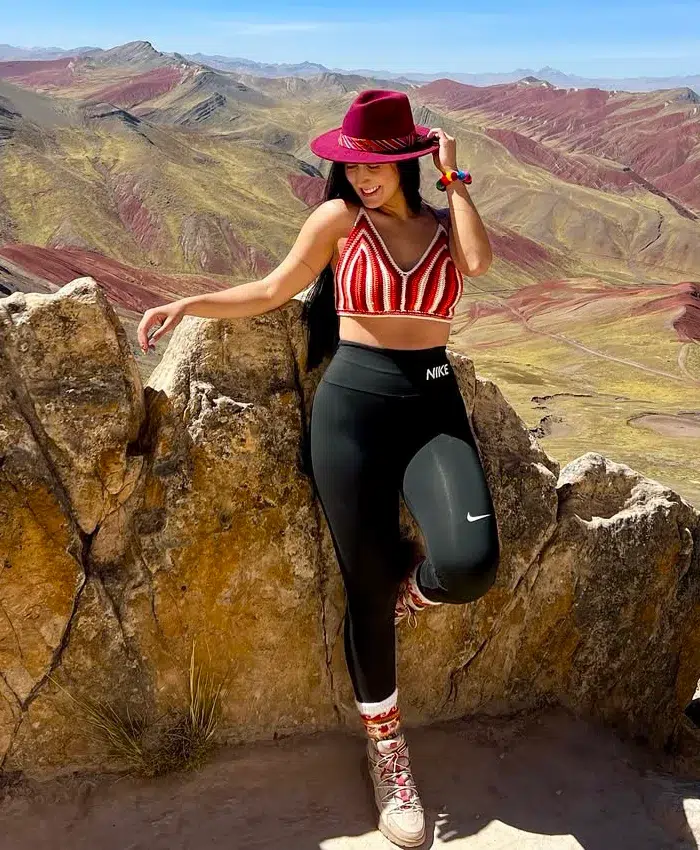 Una turista posa entre formaciones rocosas naturales, disfrutando de la vista panorámica.