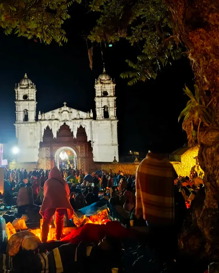 Pilgrims gather around glowing bonfires at night, wrapped in warm clothing while waiting for an Andean celebration in the highlands near Cusco.