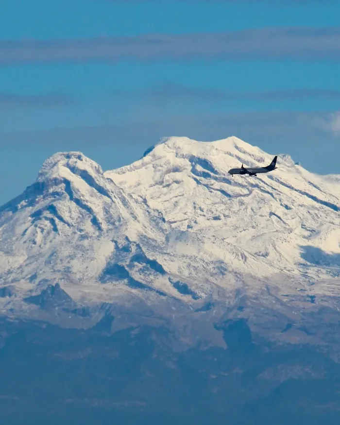 Snow-capped Salkantay Mountain rises above rugged rock formations, contrasting with Mexico’s volcanic landscapes, showcasing the natural diversity of Latin America’s high-altitude regions.