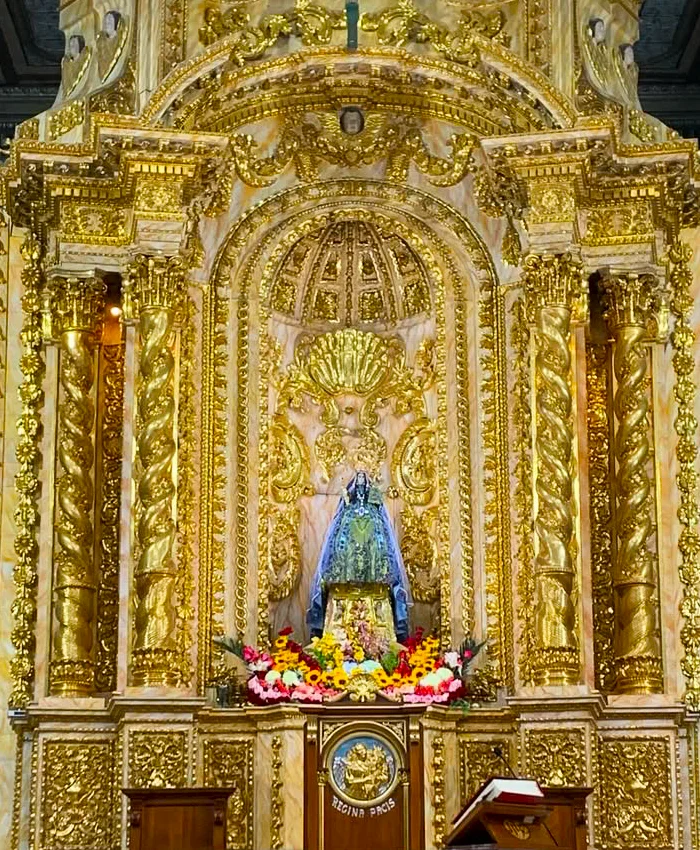 La iluminación resalta el brillo dorado del retablo, otorgándole un aspecto majestuoso y sagrado.
