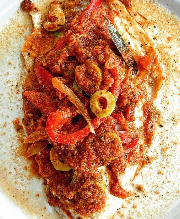 La salsa roja resalta sobre el fondo blanco del plato, invitando a disfrutar de cada bocado.