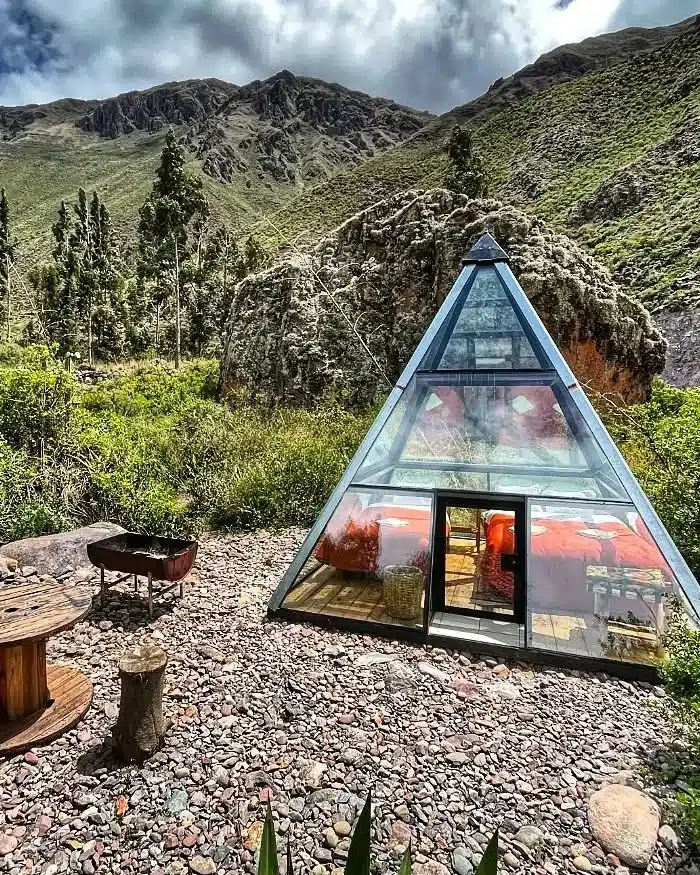 A transparent lodge in the Cusco highlands allows travelers to sleep under the stars, surrounded by natural scenery, mountains, and clear night skies.
