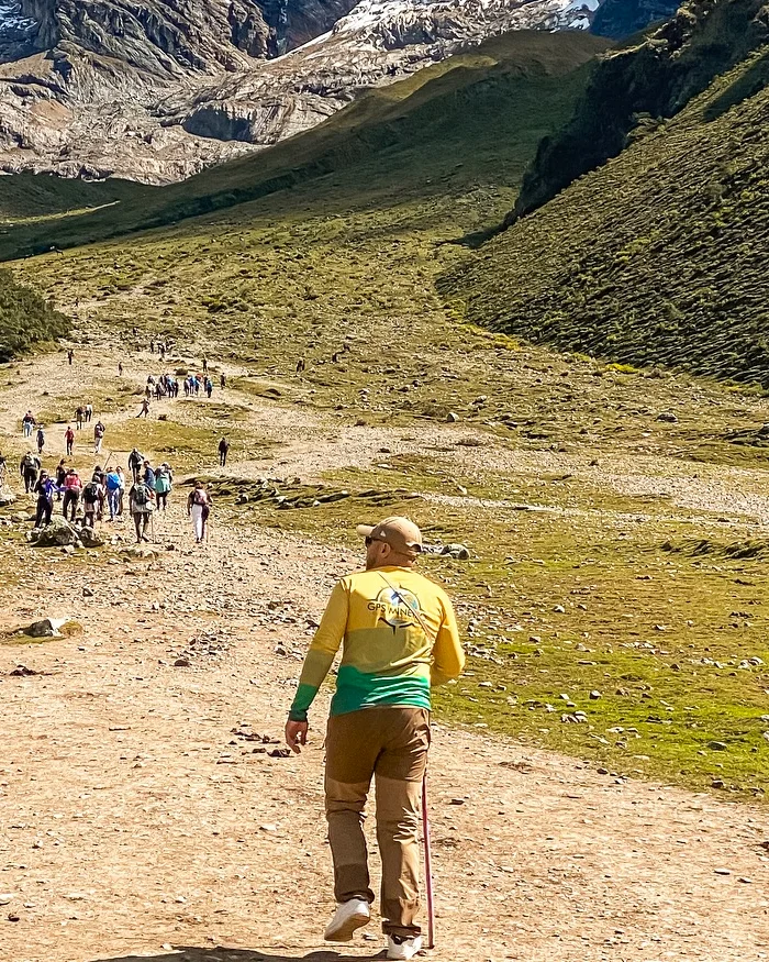 El viajero, vestido con ropa de montaña y bastón de trekking, rumbo a la Laguna Humantay.