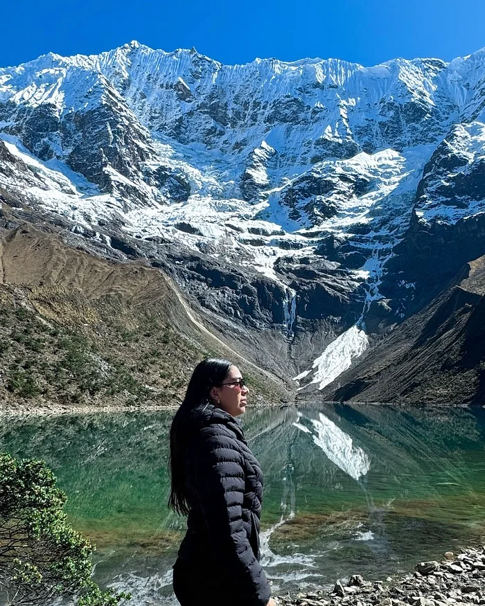 El agua turquesa del lago refleja con nitidez las montañas nevadas que lo rodean.