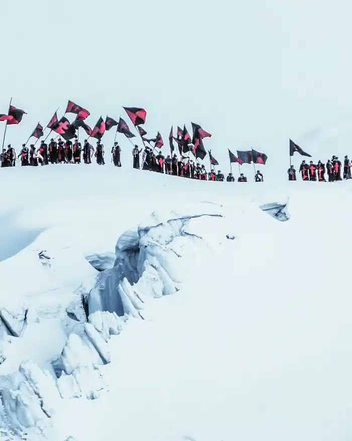 A long line of pilgrims climbs the snowy slopes of Sinakara mountain, many wearing traditional clothing, during the Qoyllur Rit’i pilgrimage near Cusco.