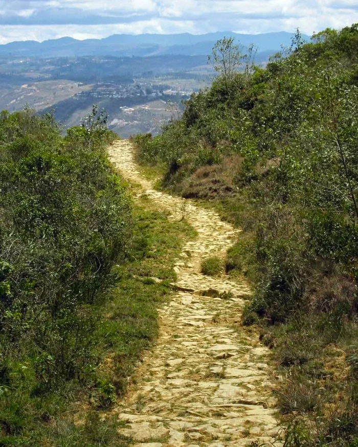 Un antiguo camino de piedras que serpentea a través de un paisaje natural.