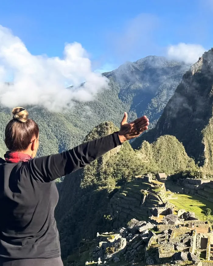 Frente a ella se despliega la impresionante ciudadela inca de Machu Picchu iluminada por la luz de la mañana.