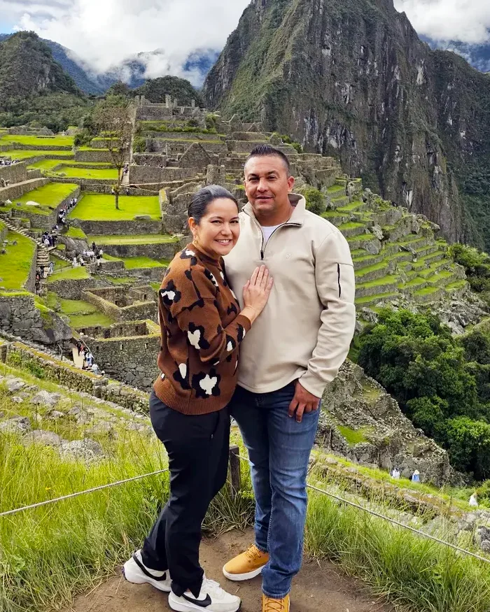 La ciudadela inca se extiende a sus espaldas con sus terrazas verdes perfectamente alineadas.