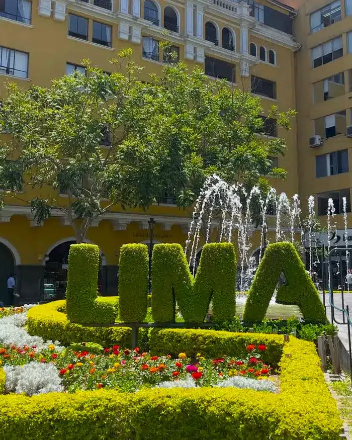 Letrero de Lima rodeado de jardines durante la primera parada de un viaje por Perú