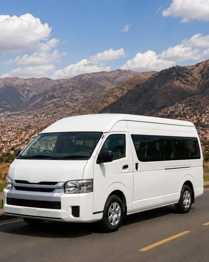 La minivan cuenta con amplias ventanas laterales y espacio interior para pasajeros, características habituales en los traslados turísticos.