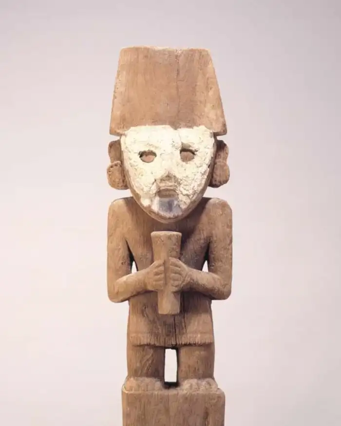 Figura antropomorfa de madera asociada con la cultura Chimú exhibida en una colección arqueológica