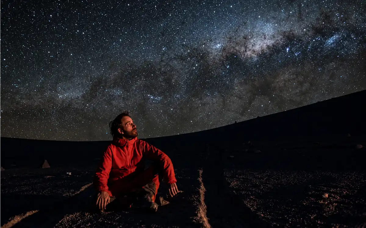 Viajera contemplando la Vía Láctea bajo un cielo despejado en el desierto de Atacama