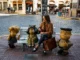 Turista sentada junto a las esculturas de Mafalda, Susanita y Manolito en el Paseo de la Historieta, Buenos Aires.