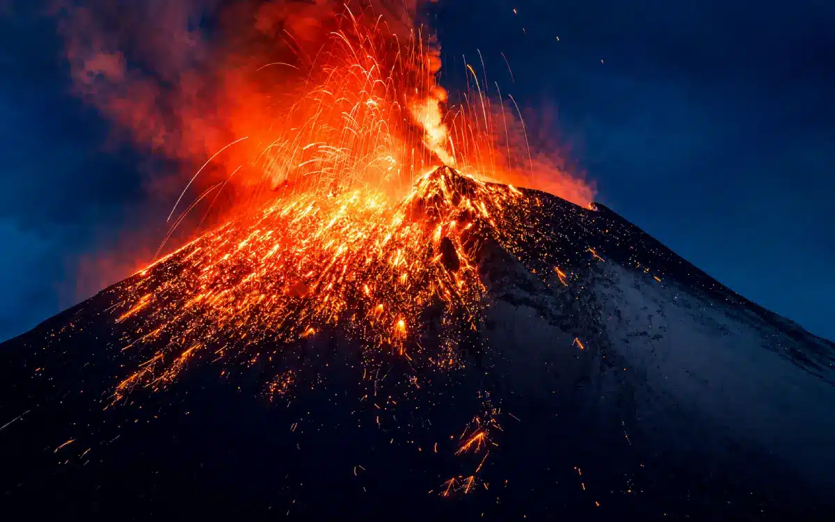 Volcán Popocatépetl en erupción nocturna con lava incandescente y cenizas