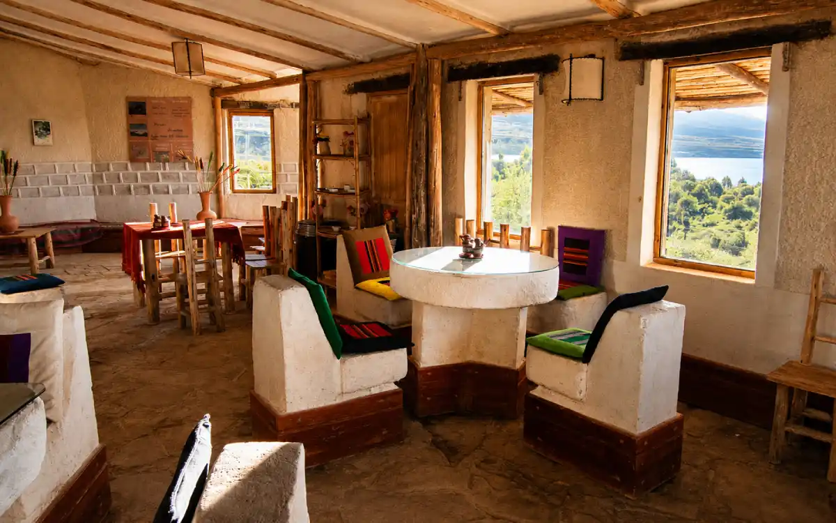 Comedor del hotel Tayka de Sal en Bolivia con ambiente rústico, mesas de madera y vista panorámica.