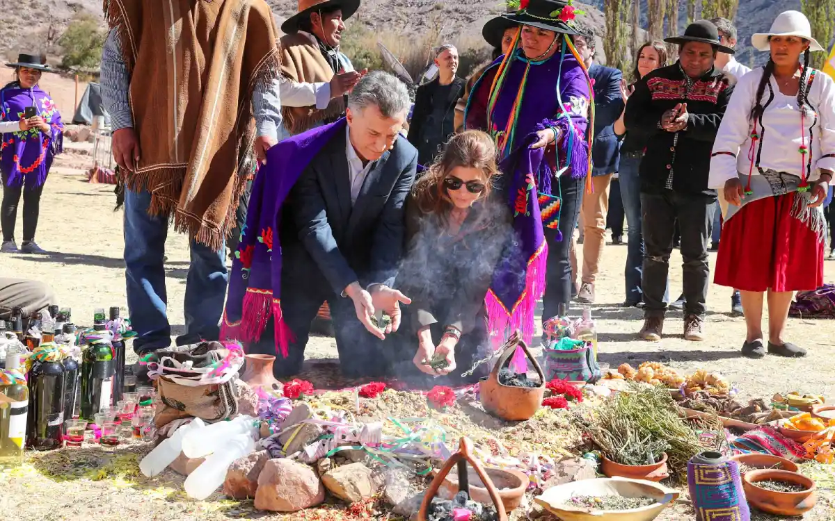Visitantes participando en una ceremonia andina de pago a la tierra, con ofrendas y personas locales alrededor.