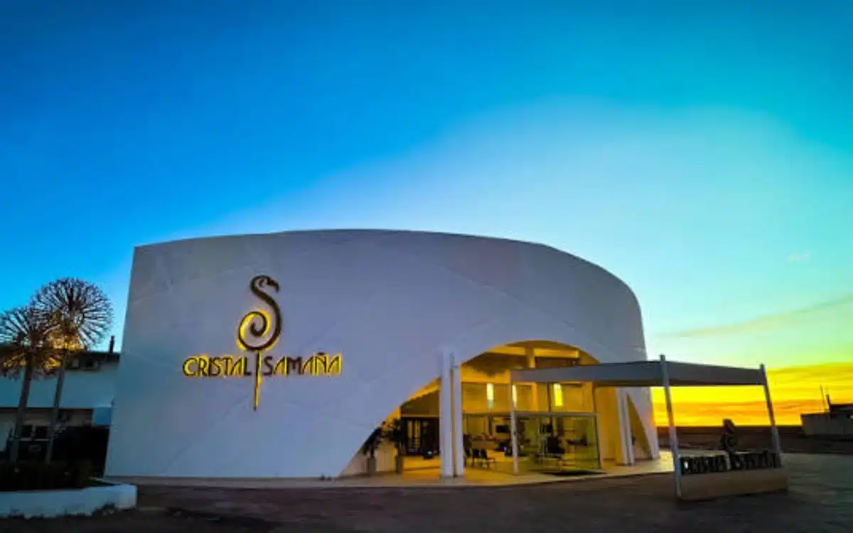 Fachada del hotel Cristal Samaña en Uyuni con luces cálidas y cielo de atardecer sobre el paisaje boliviano.