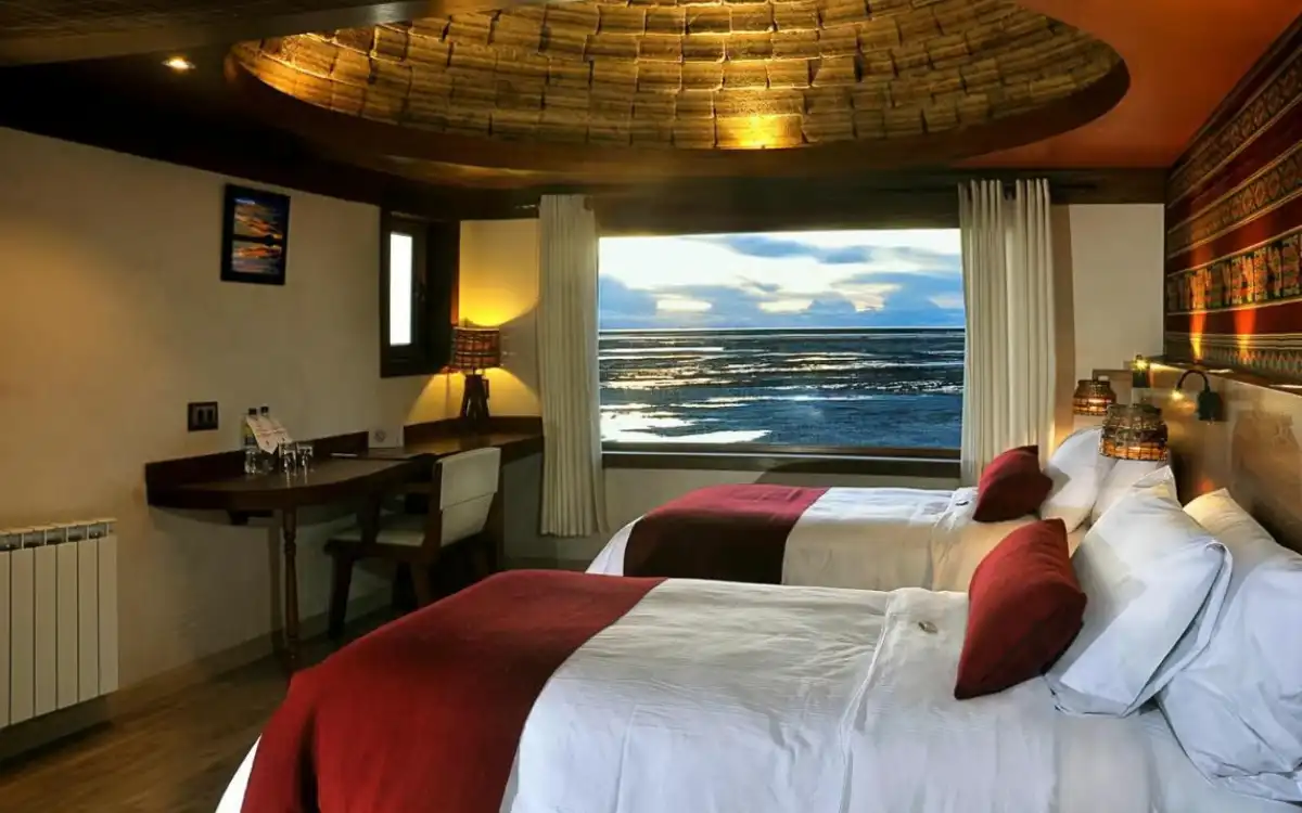 Double hotel room with Andean decor, spacious beds, and a window overlooking the Uyuni Salt Flat.