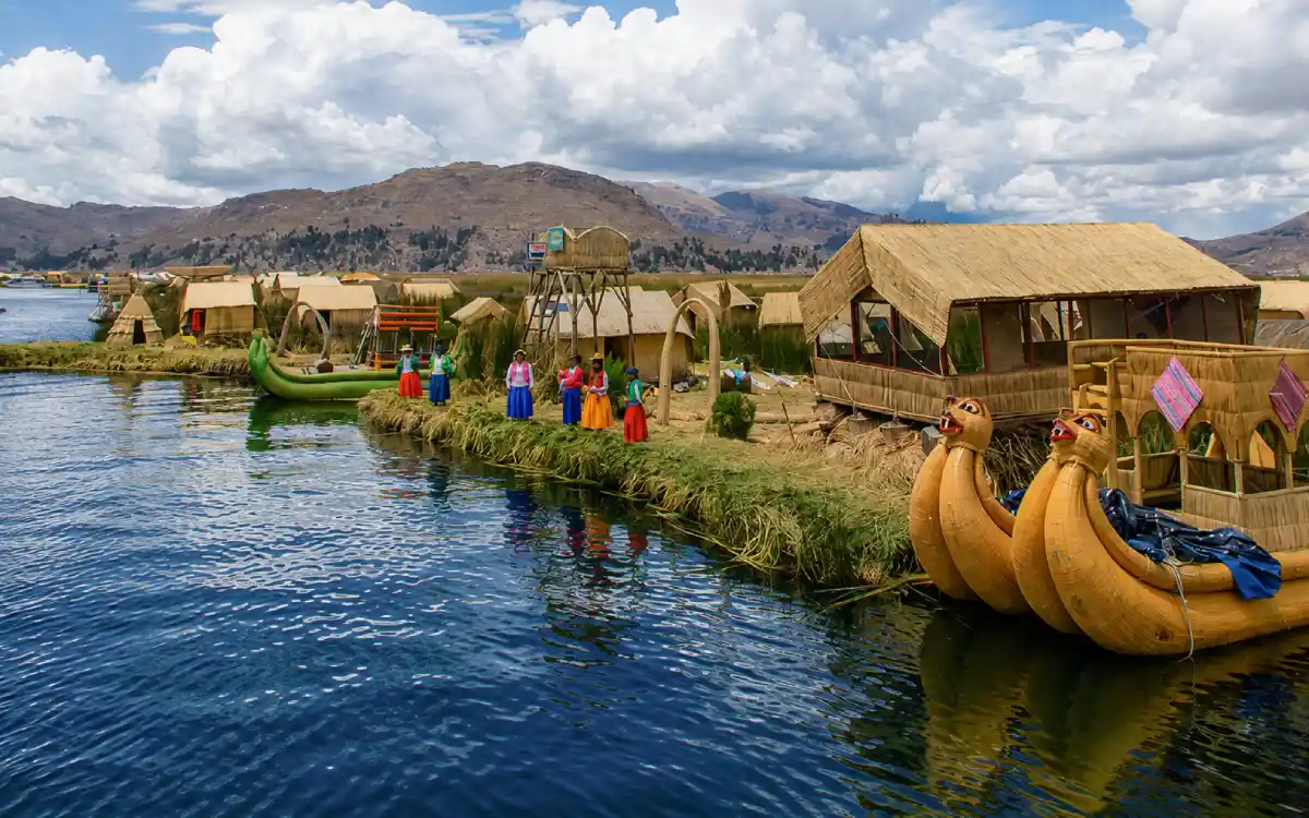 Islas flotantes de los Uros en el lago Titicaca con casas de totora, botes tradicionales y pobladores locales en Puno