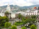 Plaza Mayor de Quito en Ecuador, con bandera nacional, estatua central, edificios coloniales y montañas al fondo.