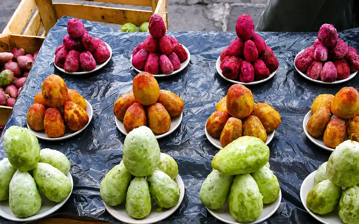 Tunas peladas de diferentes colores agrupadas en platos, con variedades verdes, amarillas y rojas listas para consumir.