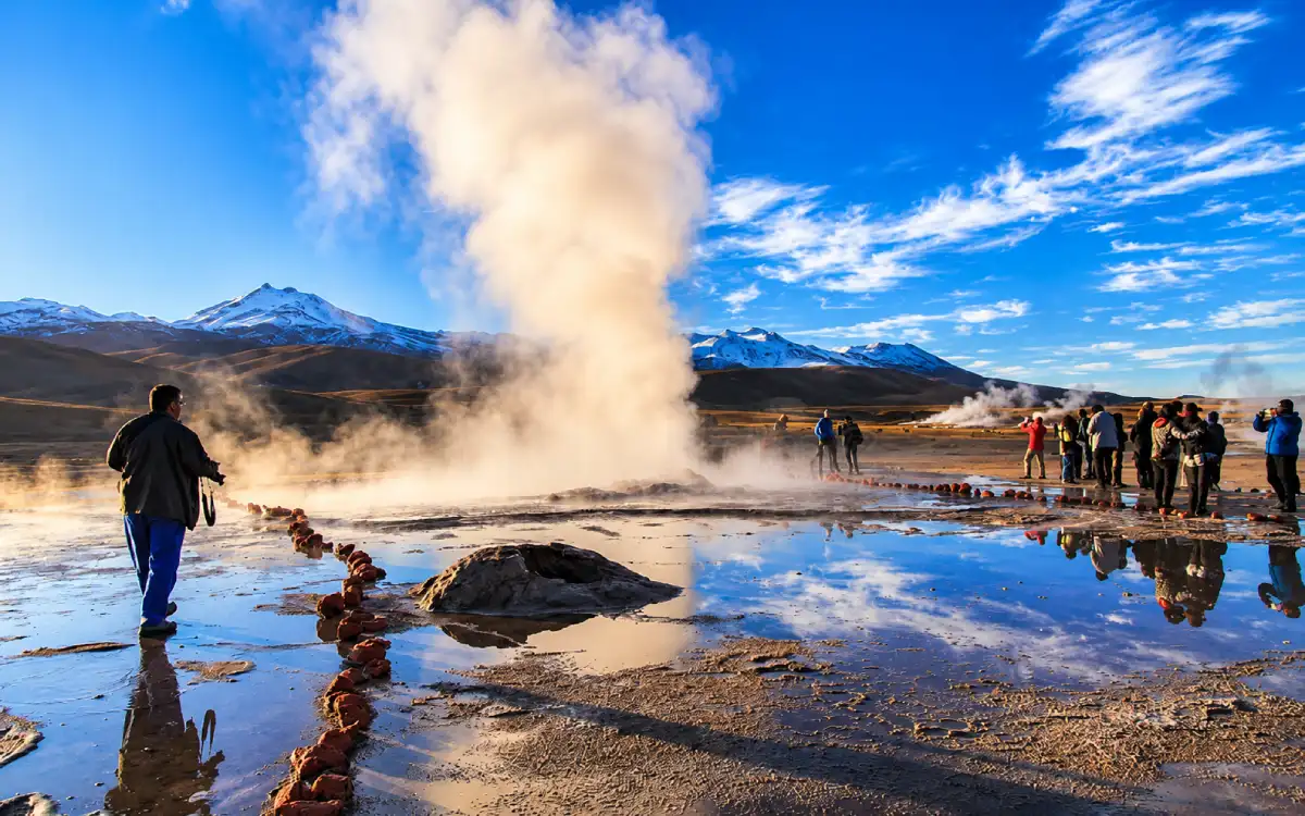 Viajeros observando columnas de vapor en los Géiseres del Tatio durante las primeras horas