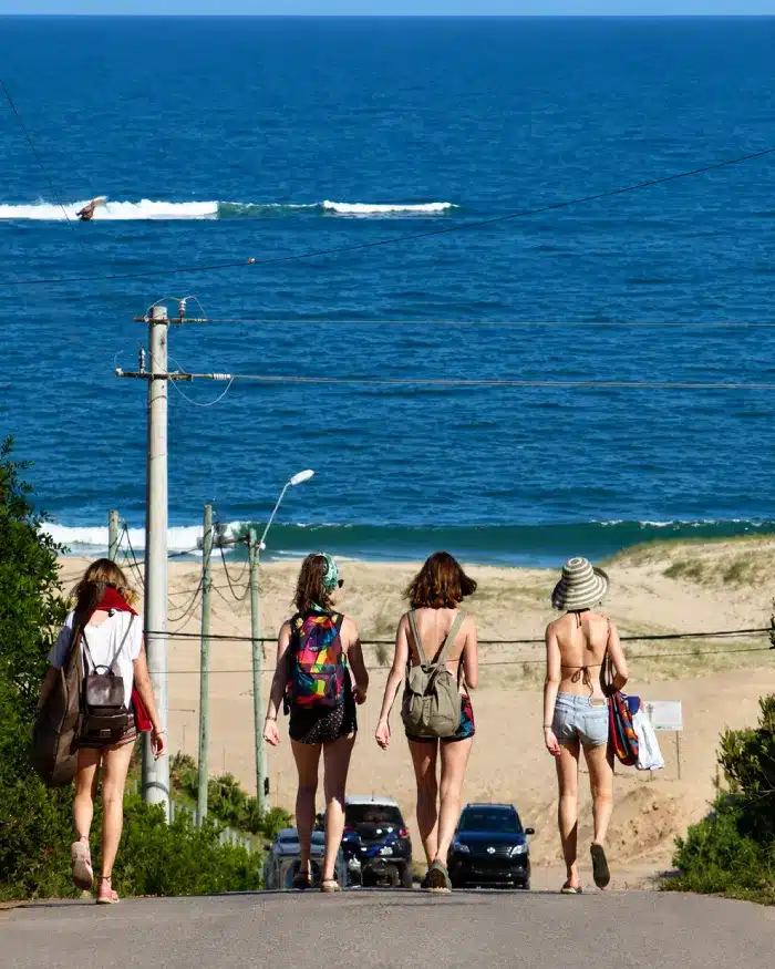 Grupo de viajeras caminando hacia una playa de Punta del Diablo en Rocha, Uruguay