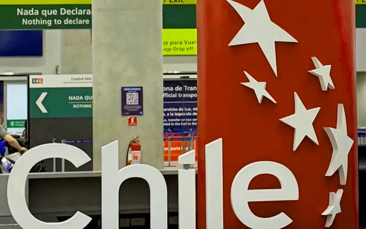 El aeropuerto presenta una zona de bienvenida con información para pasajeros, señalización de salida y áreas de revisión.