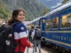 La imagen muestra a una turista lista para subir al tren y continuar su ruta hacia la ciudadela inca.