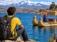 El turista observa el lago Titicaca con montañas al fondo y elementos tradicionales de la cultura local.