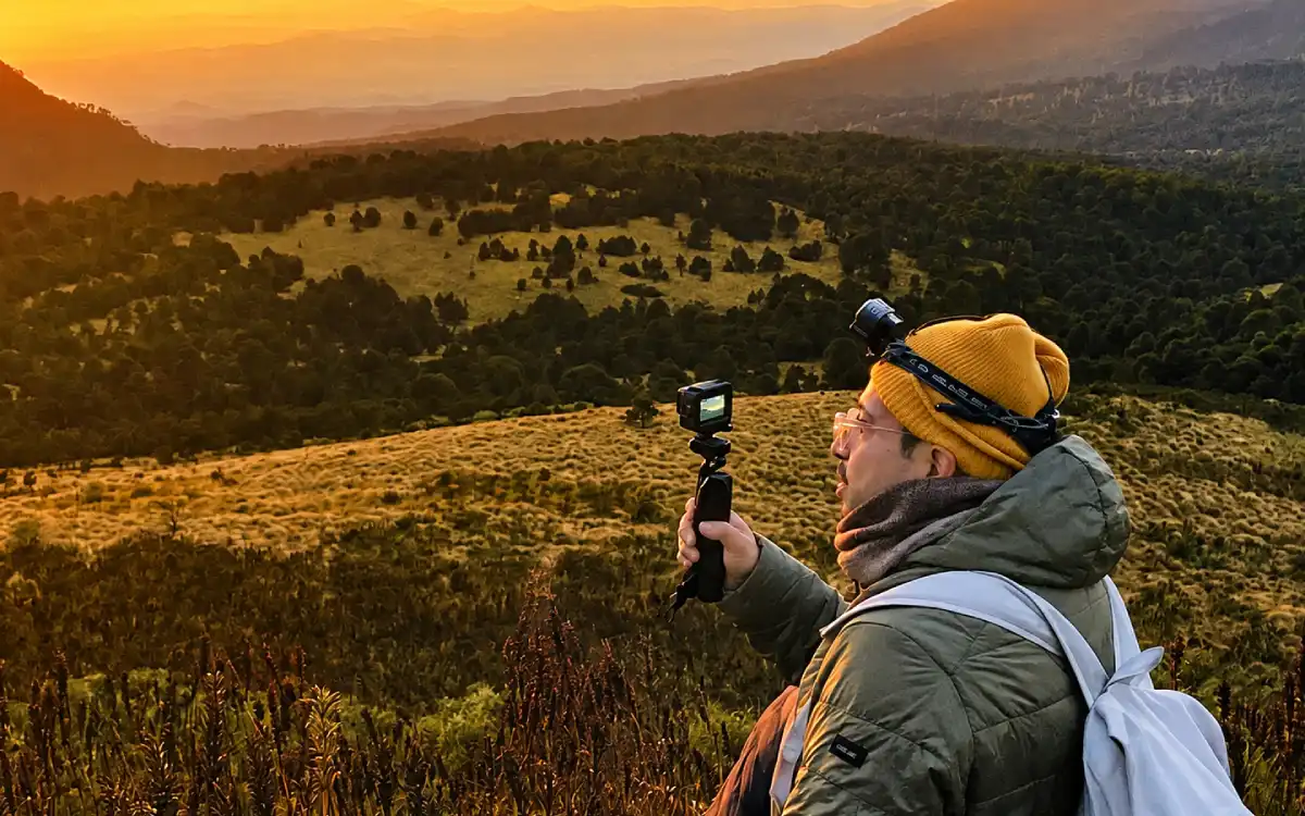 Viajero fotografiando el paisaje montañoso de Iztaccíhuatl desde una zona de campamento autorizada