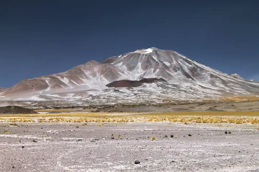 Incahuasi Volcano with arid slopes and a partially snow-covered summit in the high-altitude landscape of the central Andes.