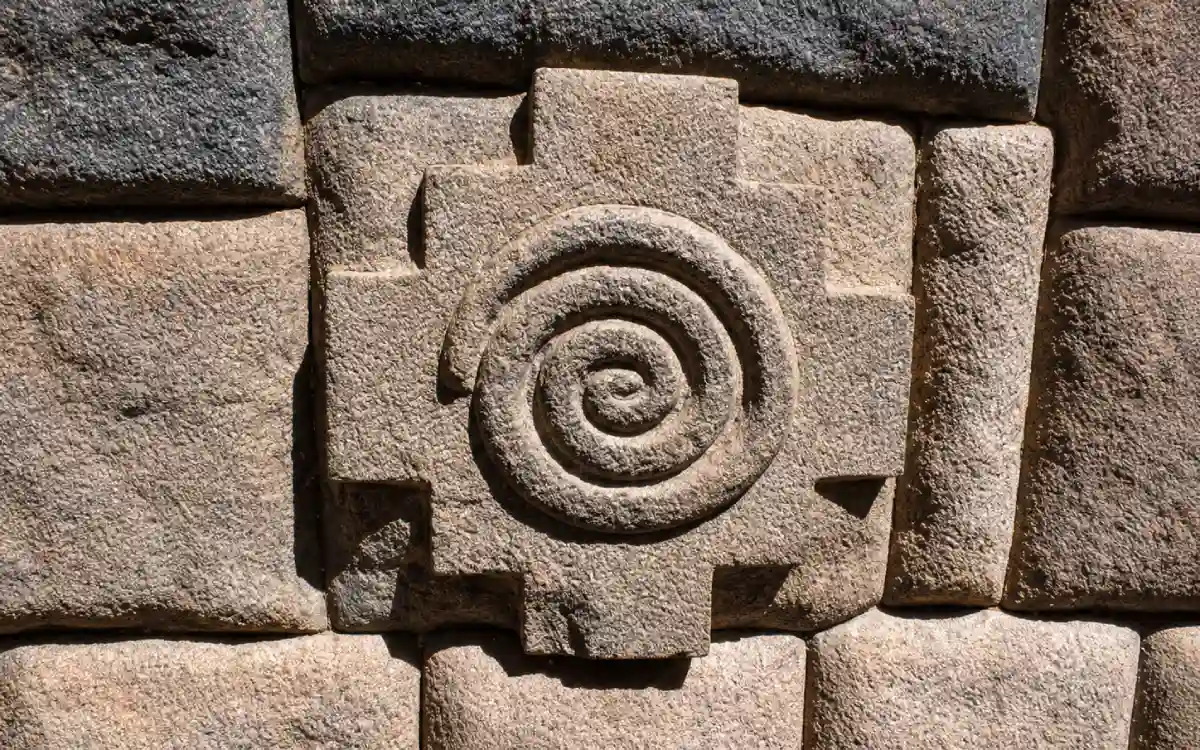 Figura de chakana tallada sobre un muro de piedra del complejo arqueológico de Ollantaytambo en Cusco