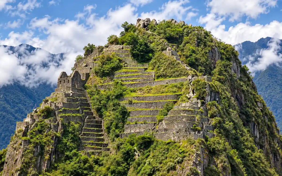 Huayna Picchu con terrazas y construcciones incas sobre sus empinadas laderas verdes