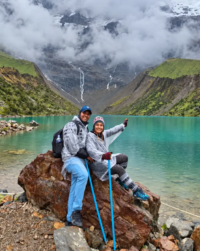 Pareja frente a la Laguna Humantay durante una jornada con neblina y llovizna