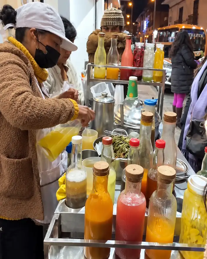 Vendedora preparando emoliente con frutas en una carreta de las calles de Cusco