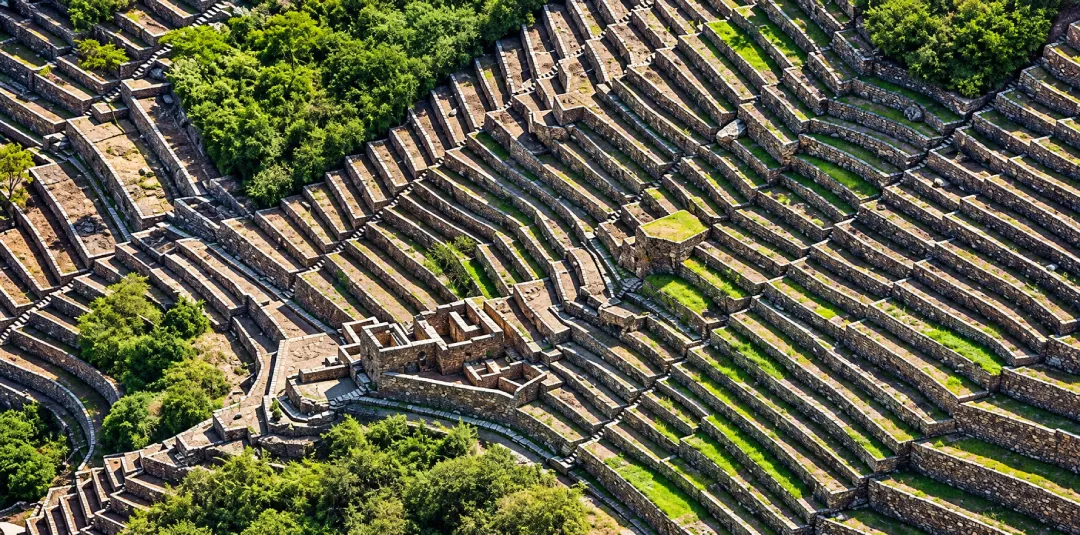 Stepped Inca terraces and stone buildings across the steep Choquequirao archaeological complex