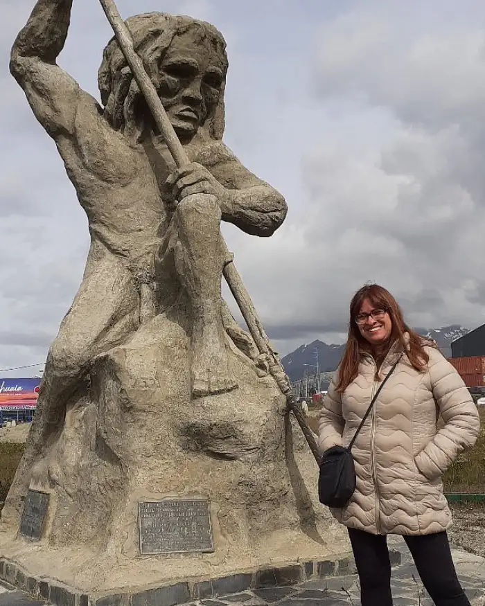 Viajera junto a monumento dedicado al pueblo Yámana en la ciudad de Ushuaia