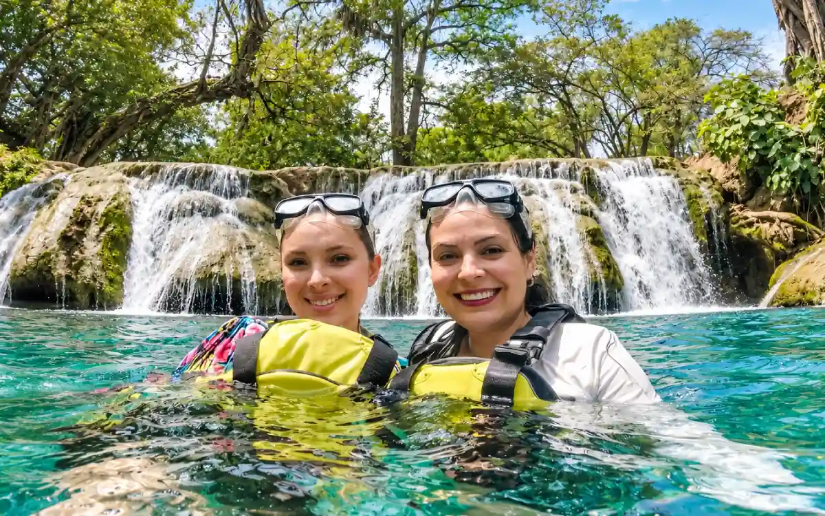 Visitantes nadando en las pozas de Tamasopo durante un día soleado